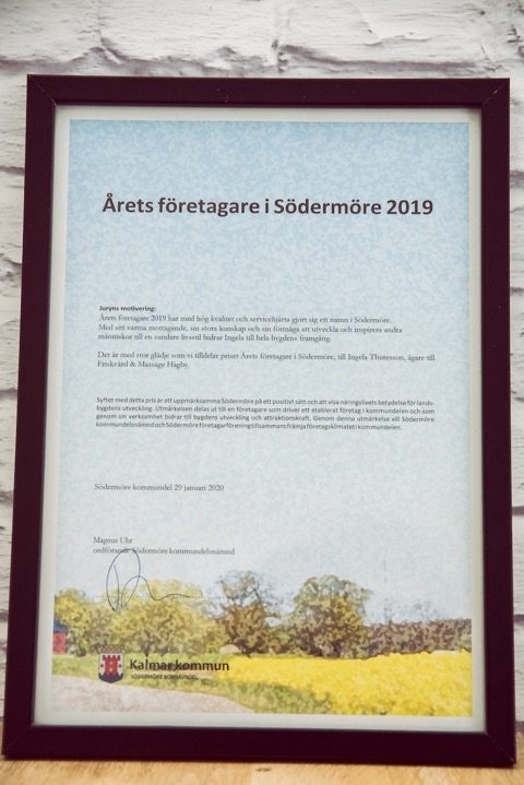 Inramat diplom ”Årets företagare i Södermöre 2019” på en vit tegelvägg